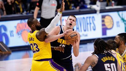 Nikola Jokic ataca la canasta frente a la cobertura de LeBron James.