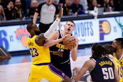 Nikola Jokic ataca la canasta frente a la cobertura de LeBron James.