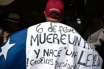 Un hombre sostiene una bandera con la leyenda "6 de febrero, muere un hombre y 'nace una leyenda'. ¡Gracias, presidente Piñera!", mientras se llevan a cabo las exequias en honor al exmandatario.