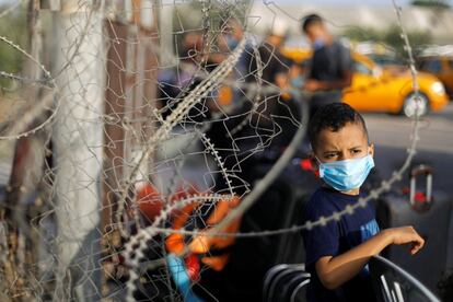 Un niño con una máscara protectora espera salir del cruce fronterizo palestino de Rafah con Egipto, en el sur de la Franja de Gaza. Este paso, cerrado debido a la pandemia por el coronavirus, fue reabierto parcialmente este lunes, 28 de septiembre.