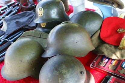 Los expositores de la feria de objetos militares vendían cascos de guerra, medallas, monedas de la época, armas, ropas y otros adornos bélicos durante la recreación histórica de la Batalla del Ebro, en Fayón, Zaragoza.