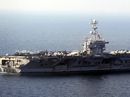 Los militares iran&iacute;es fotograf&iacute;an un portaaviones de EE UU cerca de las aguas donde realizan maniobras, en el estrecho de Ormuz.