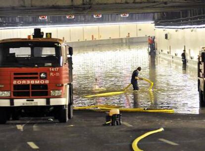 Los bomberos achican el agua embalsada en uno de los túneles de la M-30 (a la altura del puente de Segovia) el pasado 10 de septiembre.