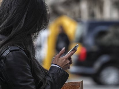 Una dona consulta el mòbil al passeig de Gràcia.