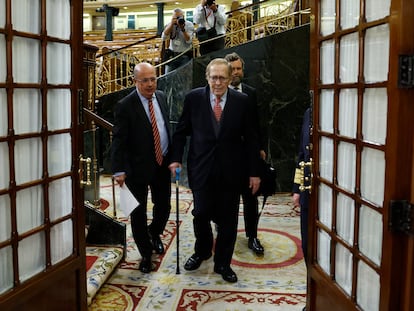 Ramón Tamames abandona el hemiciclo acompañado por los diputados de Vox Ignacio Gil (i) e Iván Espinosa de los Monteros (d).