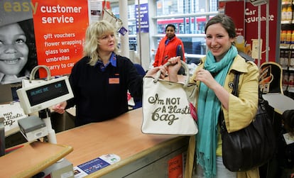 Una clienta comprando el bolso 'I'm Not A Plastic Bag' de Anya Hindmarch en la tienda Sainsbury's de Camden, en Londres, el 25 de abril de 2007.