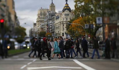 Peatones cruzando un semáforo de la Gran Vía de Madrid.