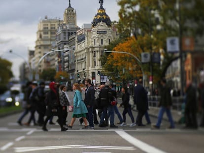 Peatones cruzando un semáforo de la Gran Vía de Madrid.