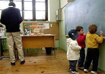 Ajenos a la lucha electoral, muchos niños han vuelto al colegio pese a ser domingo. Eso sí, hoy les acompañaban sus padres y no había profesores, al menos trabajando. En la imagen, un grupo de niños dibuja en la pizarra de una escuela de Pamplona.