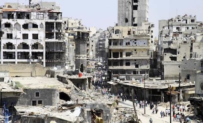 Un grupo de civiles llega a las ruinas de Homs el s&aacute;bado pasado tras la evacuaci&oacute;n de los rebeldes. 