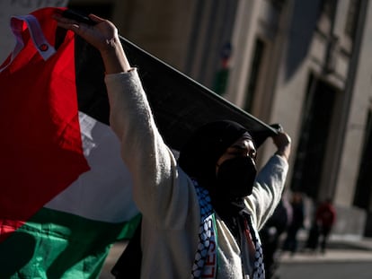 Una mujer eleva una bandera de Palestina en una manifestación en apoyo a los gazatíes, en Nueva York.