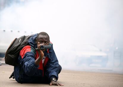 Un periodista ugandés graba con el lanzamiento de gas lacrimógeno por parte de los antidisturbios para dispersar a los activistas, encabezados por el músico convertido en político, Robert Kyagulanyi, durante una manifestación contra nuevos impuestos, incluido un impuesto sobre el acceso a las plataformas de medios sociales en Kampala (Uganda).