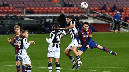 Messi intenta cabecear el balón entre varios contrarios.