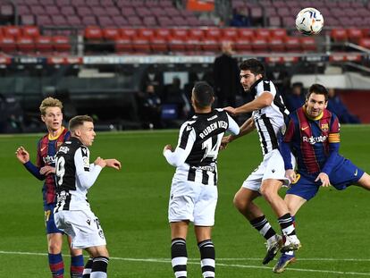 Messi intenta cabecear el balón entre varios contrarios.