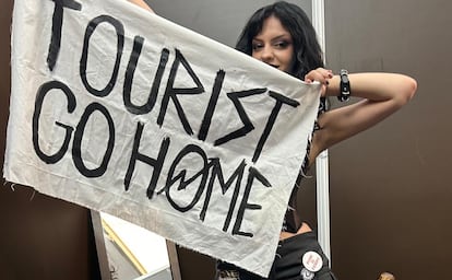 Una de las componentes del grupo punk madrileño Lucy, con la pancarta que exhibieron en la edición pasada de Mad Cool: "Tourist Go Home" (Turista, vete a casa).