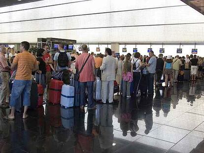 Viajeros haciendo cola ayer en la terminal B del aeropuerto de El Prat (Barcelona).