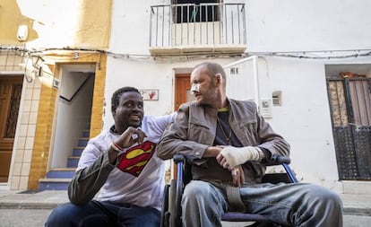 El senegalés Gorgui Lamine Sow y el hombre al que salvó Alex Caudeli, este martes, frente a la casa incendiada.