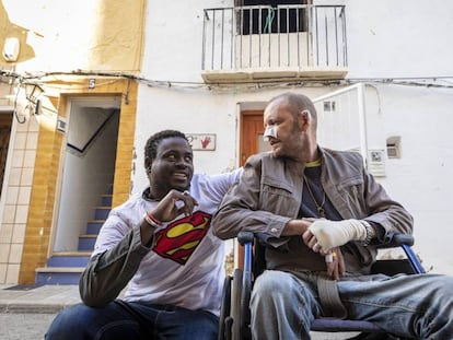 El senegalés Gorgui Lamine Sow y el hombre al que salvó Alex Caudeli, este martes, frente a la casa incendiada.
