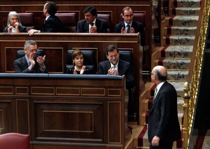 El presidente del Gobierno, Mariano Rajoy; la vicepresidenta, Soraya Sáenz de Santamaría, y el ministro de Justicia, Alberto Ruiz Gallardón, aplauden a Cristóbal Montoro en una de sus intervenciones.