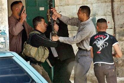 Un policía palestino (sin armas) forcejea con un militante de las Brigadas de los Mártires de Al Aqsa, ayer en Yenín.