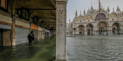 Um turista caminha pelas ruas alagadas em Veneza.