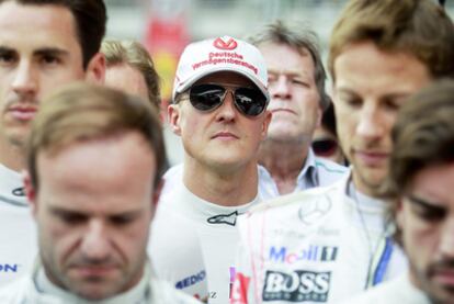 Michael Schumacher, en el centro; Barrichello, a la izquierda, y Button y Alonso, a la derecha, guardan un minuto de silencio en Nueva Delhi por el fallecimiento de Marco Simoncelli.