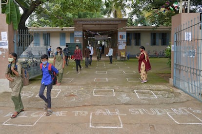 Una profesora observa la salida de los estudiantes de un colegio público de Bangalore, en India, el 23 de agosto de 2021, un día después de que en esta ciudad se haya permitido la apertura de centros educativos para alumnos de Secundaria después de un cierre que ha durado 18 meses.