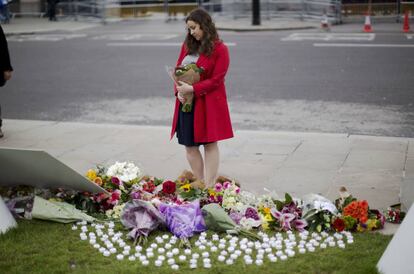 Una mujer deposita un ramo de flores en un altar improvisado en homenaje a la diputada laborista, Jo Cox, en Londres.