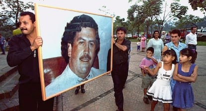 Dos hombres llevan un retrato de Escobar en el aniversario de su muerte. 