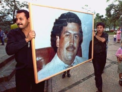 Dos hombres llevan un retrato de Escobar en el aniversario de su muerte. 