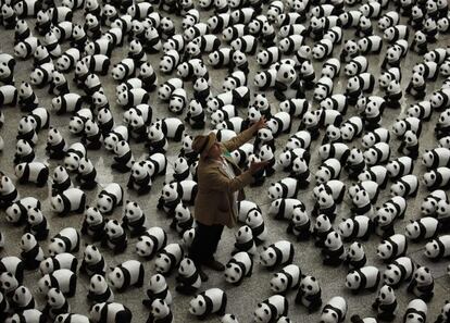 El artista francés Paulo Grangeon lanza uno de sus pandas de papel maché que forman parte de la instalación expuesta en el aeropuerto de Hong Kong.