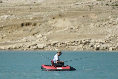 Un hombre pesca en una barca en el embalse de Canelles. 