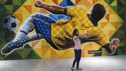 Uma garota tira uma foto em frente a painel no aeroporto de Bras&iacute;lia. 