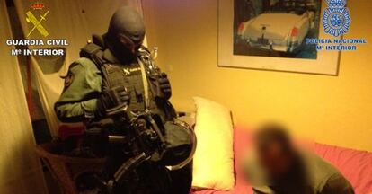 Un agente custodia a uno de los 18 detenidos en la Operación Periplo.