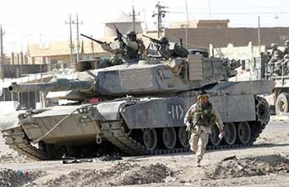 Un tanque estadounidense monta guardia ante un mercado en un suburbio de Bagdad.