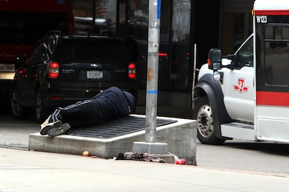 Una persona sin hogar duerme este martes en la salida del Hospital General de Toronto, en Canadá.