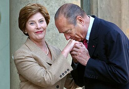 Jacques Chirac besa la mano de Laura Bush al recibirla ayer en el Elíseo.