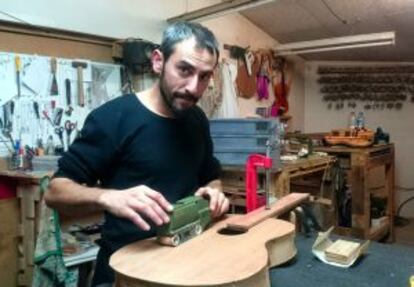 Jose Alejo treballant una guitarra al seu estudi.