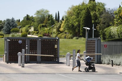 Una mujer pasea un carrito de bebé frente a la entrada de La Finca, una urbanización en Pozuelo de Alarcón, el jueves