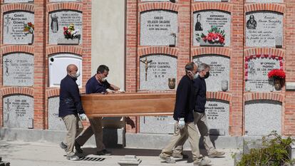 Cuatro operarios, durante el entierro de un fallecido, el pasado abril en el cementerio madrileño de la Almudena.