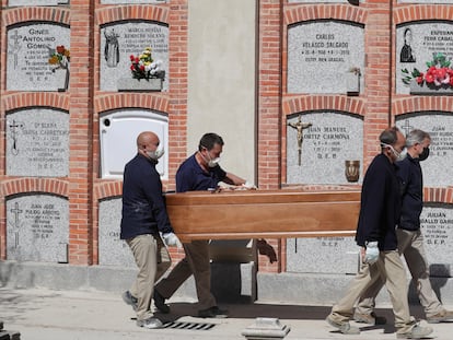 Cuatro operarios, durante el entierro de un fallecido, el pasado abril en el cementerio madrileño de la Almudena.