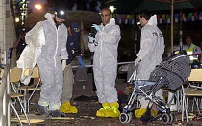 Varios policías israelíes recogen pruebas en la escena del atentado de Petah Tikva.