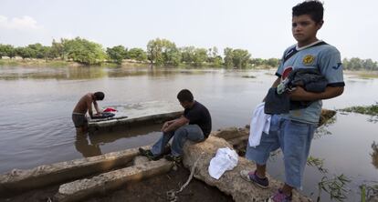 Migrantes hondureños lavan su ropa en la frontera de México y Guatemala.