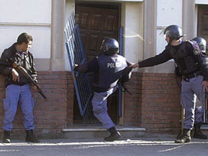 Policías argentinos echan abajo la puerta de la sede de un partido de izquierda donde se habían refugiado varios manifestantes el pasado 26 de junio.
