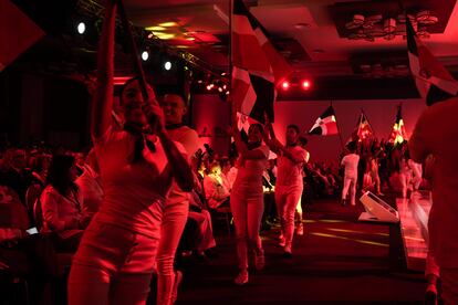 Bailarines ondean la bandera de República Dominicana.