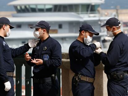 Agentes argelinos portan máscaras mientras un crucero llega al puerto de Argel el jueves 19 de marzo.