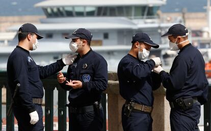 Agentes argelinos portan máscaras mientras un crucero llega al puerto de Argel el jueves 19 de marzo.