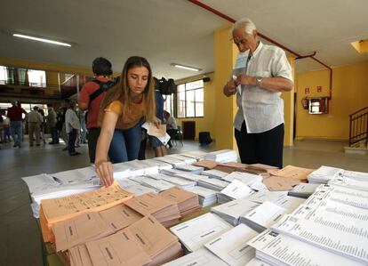GRA020 MADRID, 26/06/2016.- Varios votantes eligen las papeletas de su opción en el colegio Bernadette de Aravaca, Madrid, en la jornada de elecciones generales que vive hoy nuestro país.