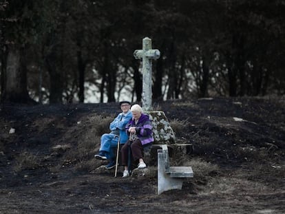 Dos ancianos descansan en una zona arrasada en Ponte Caldelas.