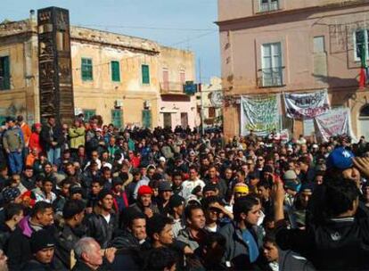 Decenas de habitantes de Lampedusa, acompañados por inmigrantes llegados a la isla del sur de Italia, protestan frente al Ayuntamiento de la localidad contra la decisión del Gobierno italiano de sustituir el actual centro de acogida por un Centro de Identificación y Expulsión.